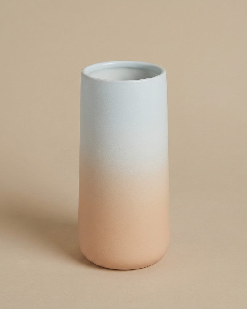 Einzelne feey Keramik-Vase 'Solio' mit Farbverlauf von Hellblau zu Pfirsich, freigestellt auf beigem Hintergrund