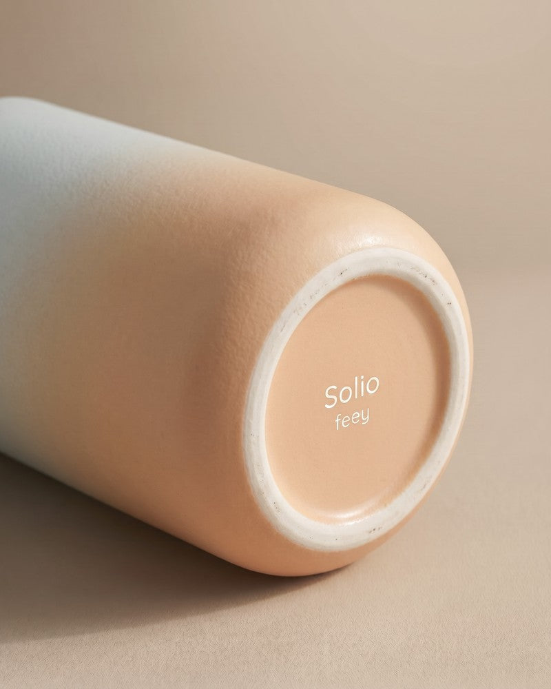 Nahaufnahme des Bodens der feey Keramik-Vase 'Solio' mit eingeprägtem 'Solio feey' Schriftzug auf der pfirsichfarbenen Glasur