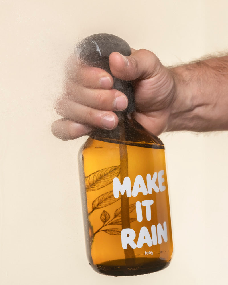 Eine Hand besprüht eine Pflanzensprher-Flasche mit der Aufschrift 